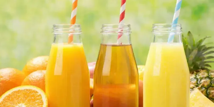 Three different juices in different bottles with straws.
